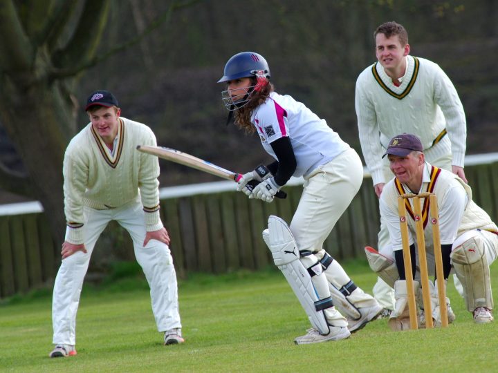 People playing cricket to encourage cricketer